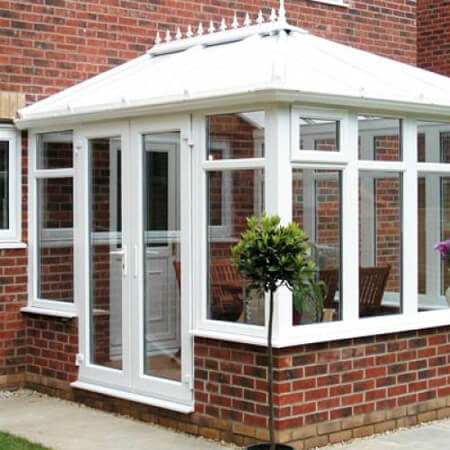 SW Plastic Conservatories. Edwardian conservatory with a white frame and red dwarf wall.