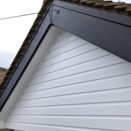 SW Plastic Roof Lines. Black barge boards set on a white, panelled house.