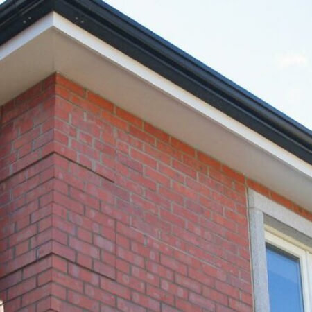 SW Plastic Roof Lines. Black guttering on a red brick house with white cladding.