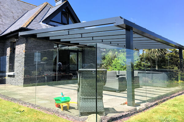 SW Plastiic Canopies. Contemporary Veranda covering a large brick patio, surrounded by a see-through glass fence.